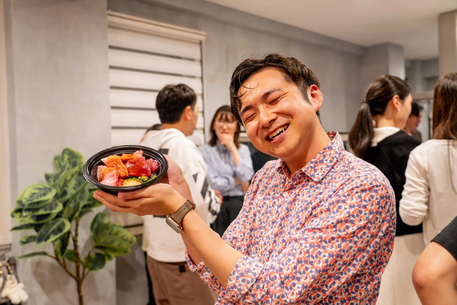 海鮮丼を手に笑顔を見せる参加者